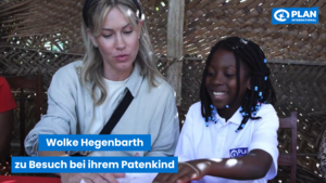 Die Schauspielerin Wolke Hegenbarth sitzt neben einem Mädchen, die lächelt. Sie schauen beide auf einen Brief. Daneben steht: "Wolke hegenbarth zu Besuch bei ihrem Patenkind."