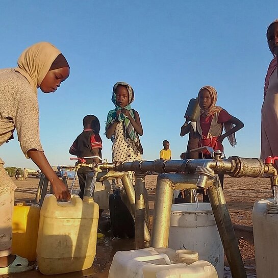 Kinder holen Wasser von der Wasserstelle in Adré