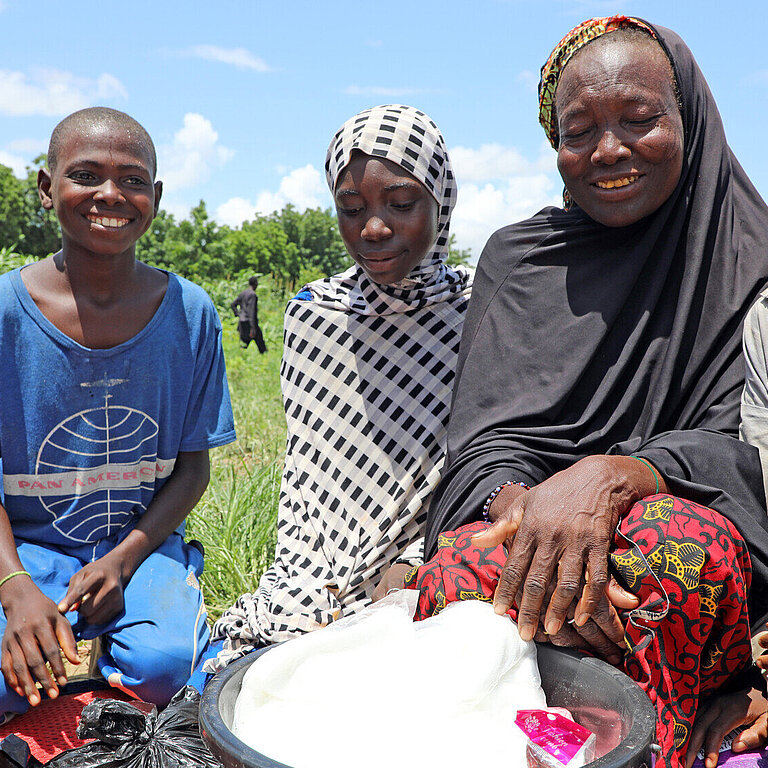 Eine Familie in Niger mit Lebensmittelhilfe, die sie von Plan erhalten hat 