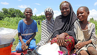 Eine Familie in Niger mit Lebensmittelhilfe, die sie von Plan erhalten hat 