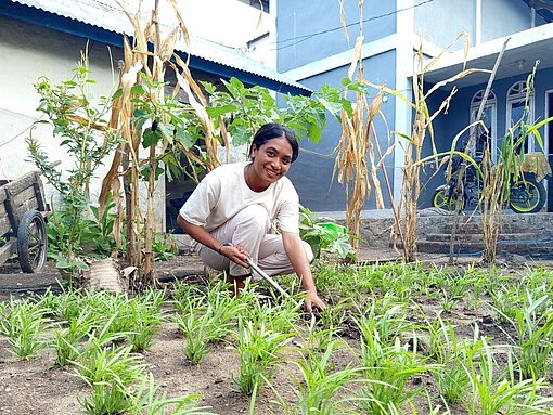 Anita arbeitet in ihrem Gemüsegarten