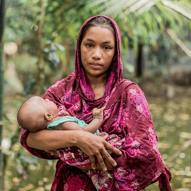 Sumi hält ihr Baby Nusrat im Arm, sie sieht traurig in die Kamera