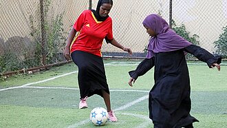 Zwei Mädchen spielen auf einem Fußballplatz