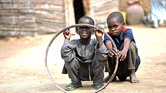 jungen-in-nigeria-spielen-mit-reifenfelge