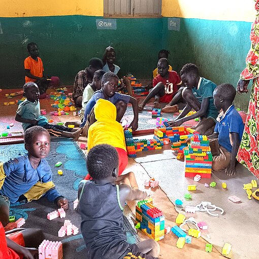 Kinder spielen in einem Raum mit Bauklötzen