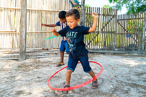 Zwei kleine Jungen versuchen, Hula-Hoop-Reifen um die Hüften kreisen zu lassen