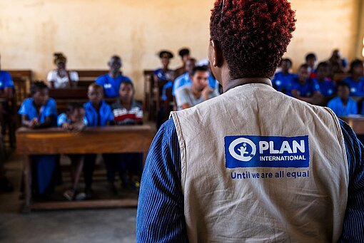 Eine Plan-Mitarbeiterin steht in einem Klassenzimmer in Cabo Delgado