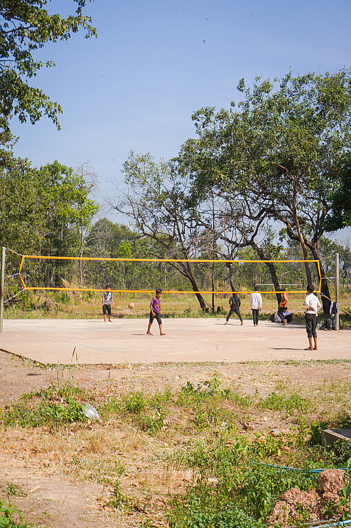 Ein Volleyballplatz im Freien, auf dem einige Kinder spielen