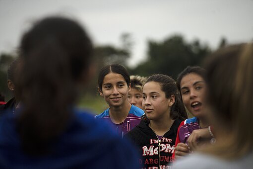Drei Mädchen des Fußballteams stehen eng zusammen