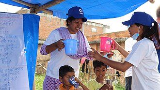 Freiwillige Helferinnen kümmern sich im die Kinder nach dem Erdbeben in Nepal © Plan 