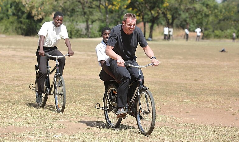 Felix Loch und malawische Kinder fahren Fahrrad