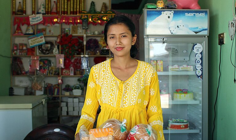 Eine junge Frau steht an einer Ladentheke
